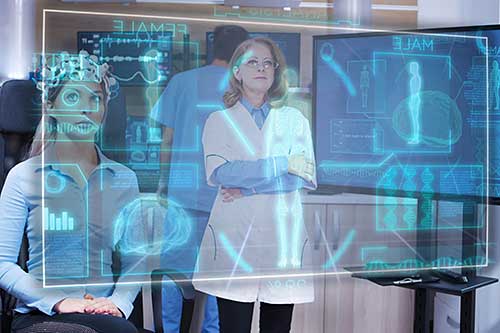 A group of people sit in front of a computer screen. A group of people sit in front of a computer screen.